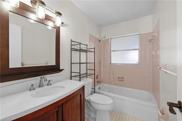 1/1 Side: Full bath featuring bathtub / shower combination, toilet, and vanity