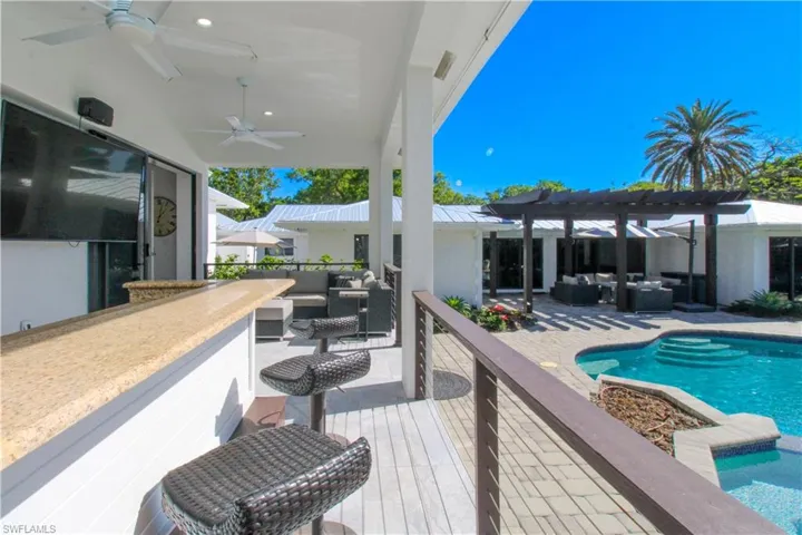 View of pool with an outdoor hangout area, ceiling fan, and a pergola