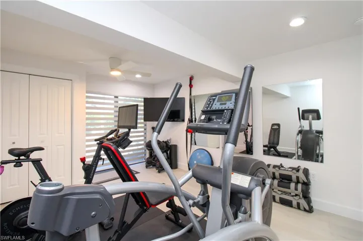 Workout area featuring light hardwood / wood-style floors and ceiling fan