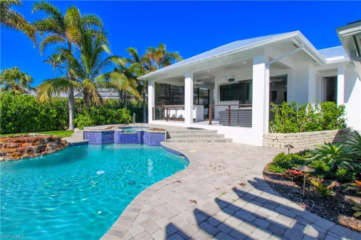 View of pool featuring ceiling fan, a patio area, and an in ground hot tub
