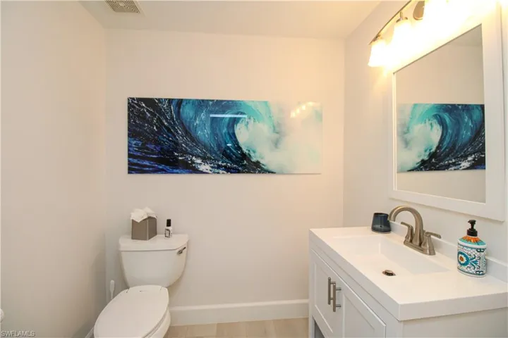Bathroom featuring vanity, hardwood / wood-style flooring, and toilet