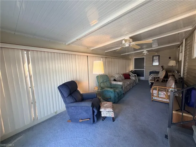 Living area featuring carpet floors and a ceiling fan