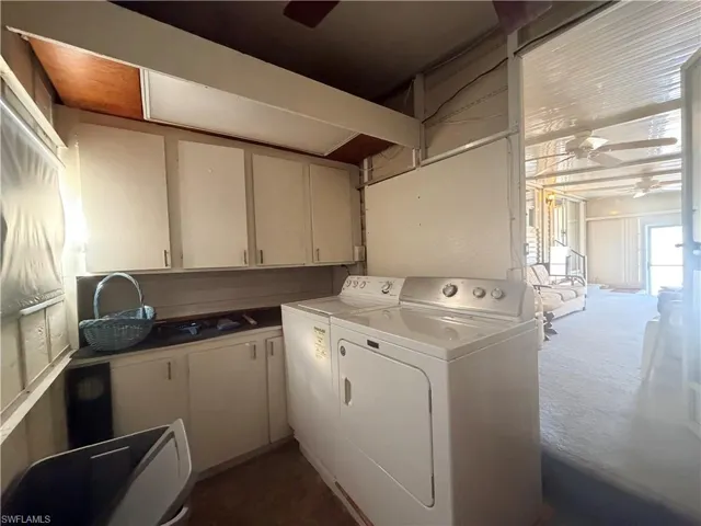 Laundry room with ceiling fan, cabinet space, independent washer and dryer, and dark carpet