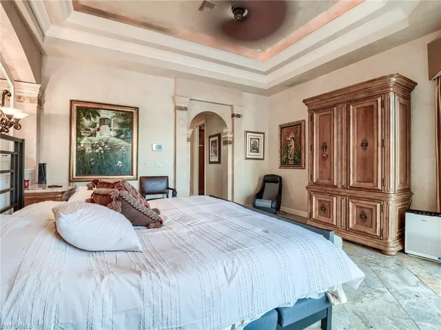 Tiled bedroom featuring a raised ceiling