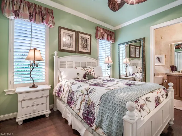Bedroom featuring connected bathroom, ceiling fan, dark wood-type flooring, and crown molding