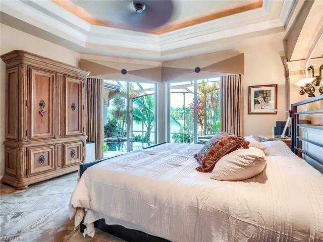 Bedroom featuring access to outside, light tile patterned floors, and a raised ceiling