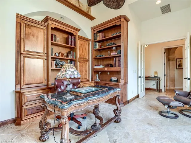 Office with light tile patterned flooring and vaulted ceiling