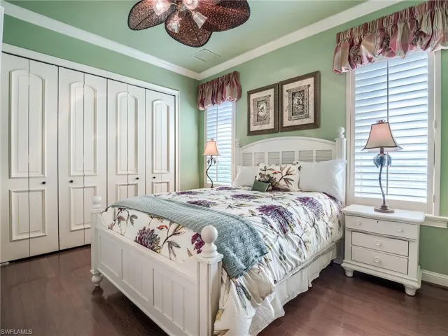 Bedroom featuring ceiling fan, dark hardwood / wood-style flooring, and ornamental molding