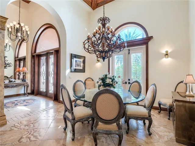 Dining space featuring a notable chandelier, light tile patterned flooring, and french doors