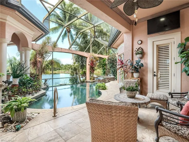 View of swimming pool with a lanai, a patio, a water view, and ceiling fan