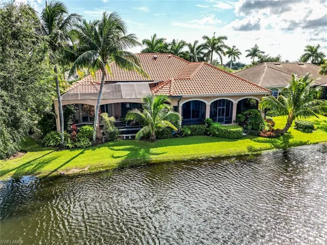 Back of house featuring a water view and a yard