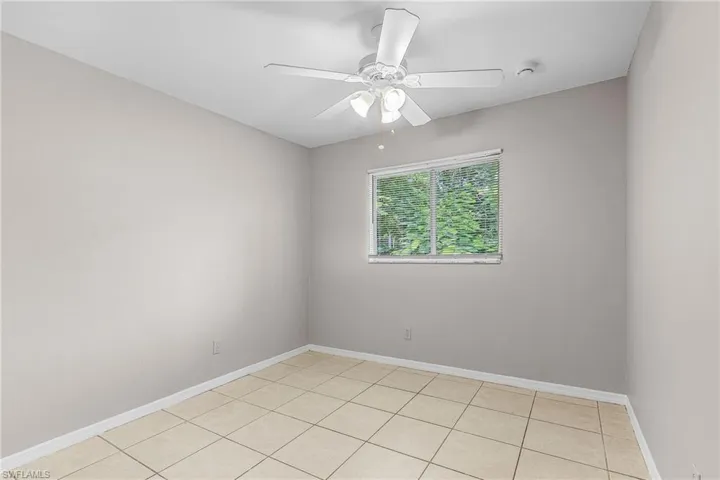 Unfurnished room featuring light tile patterned flooring and a ceiling fan