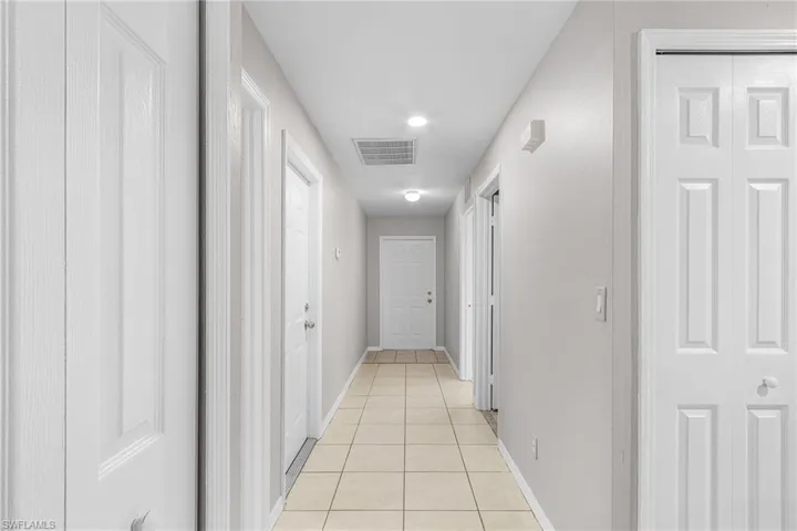 Hallway with light tile patterned flooring and recessed lighting