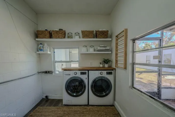 Laundry area featuring washer and clothes dryer and dark wood-style floors