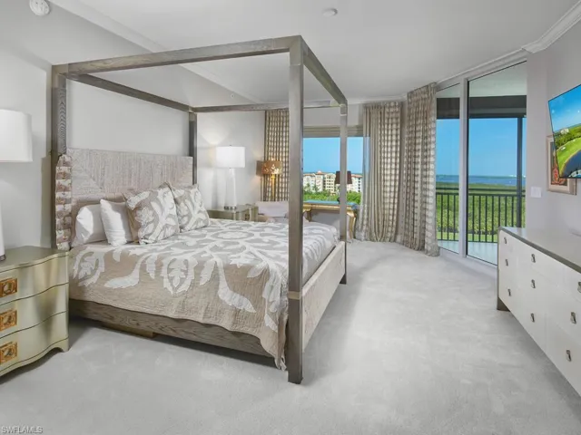 Bedroom with light carpet, crown molding, and access to outside