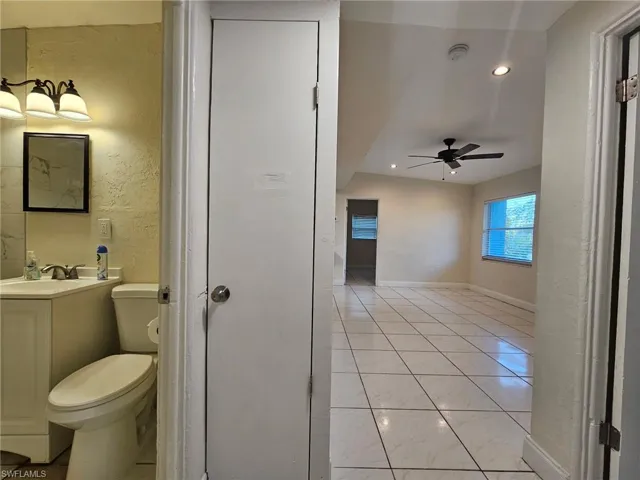 Bathroom featuring a textured wall, vanity, ceiling fan, and recessed lighting