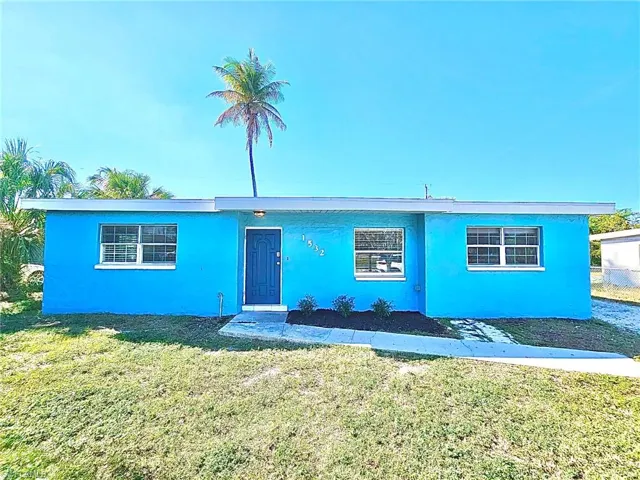 View of front of house with a front lawn and stucco siding
