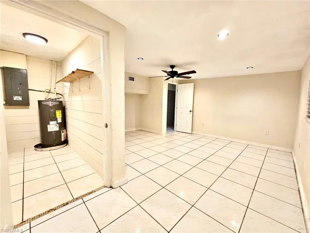 Empty room with electric panel, electric water heater, recessed lighting, a ceiling fan, and light tile patterned floors