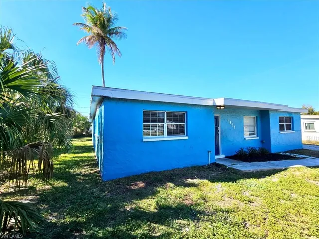 View of front of house featuring a front yard and stucco siding