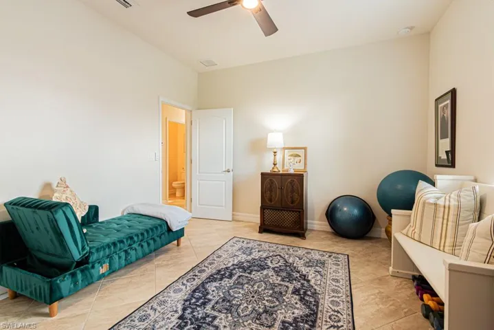Living area with ceiling fan and light tile patterned flooring