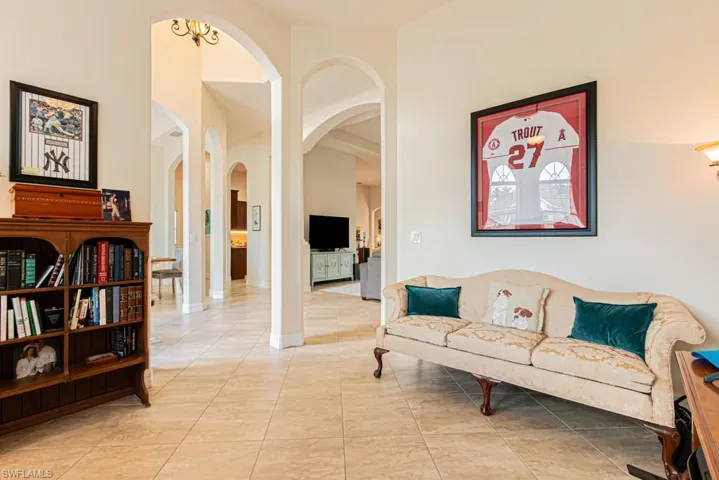 Sitting room featuring arched walkways and light tile patterned flooring