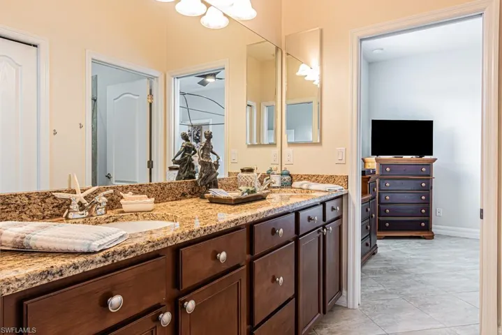 Full bathroom with double vanity and light tile patterned floors