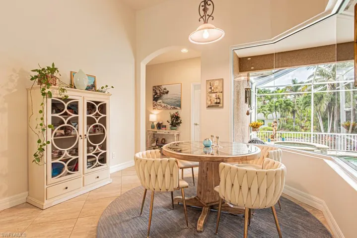 Dining room with light tile patterned floors and arched walkways
