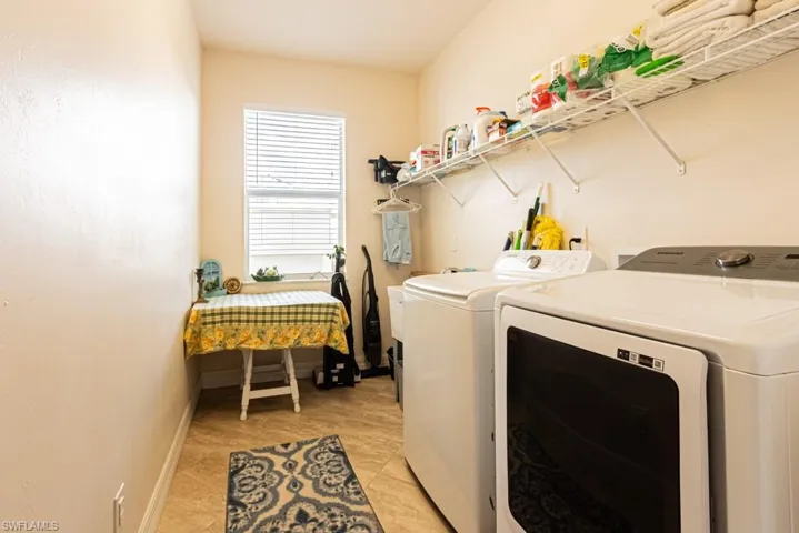 Laundry room featuring washer and clothes dryer and light tile patterned flooring