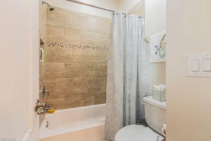 Bathroom with shower / tub combo and toilet