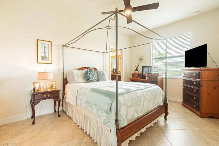Bedroom with light tile patterned floors and ceiling fan