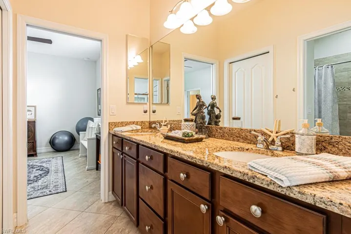 Full bath featuring double vanity, tiled shower, light tile patterned floors, and a freestanding bath