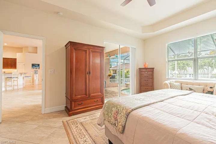 Bedroom with access to exterior, a ceiling fan, and light tile patterned flooring