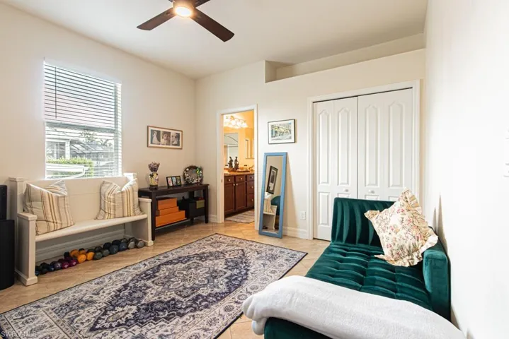 Living area featuring a ceiling fan and light tile patterned floors
