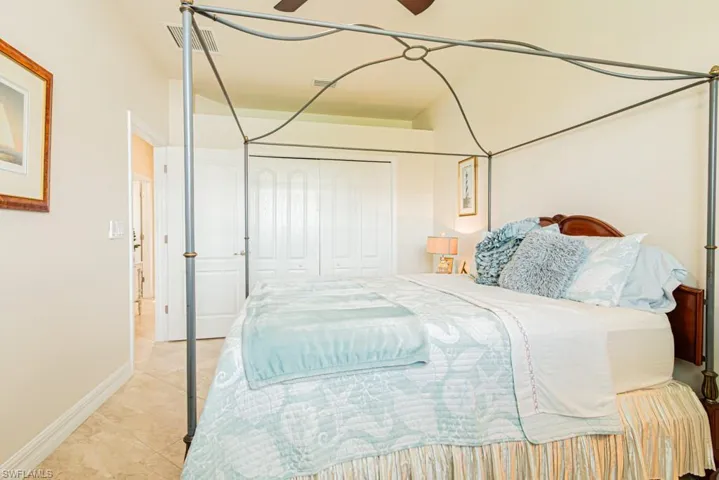 Bedroom with a closet, a ceiling fan, and tile patterned floors