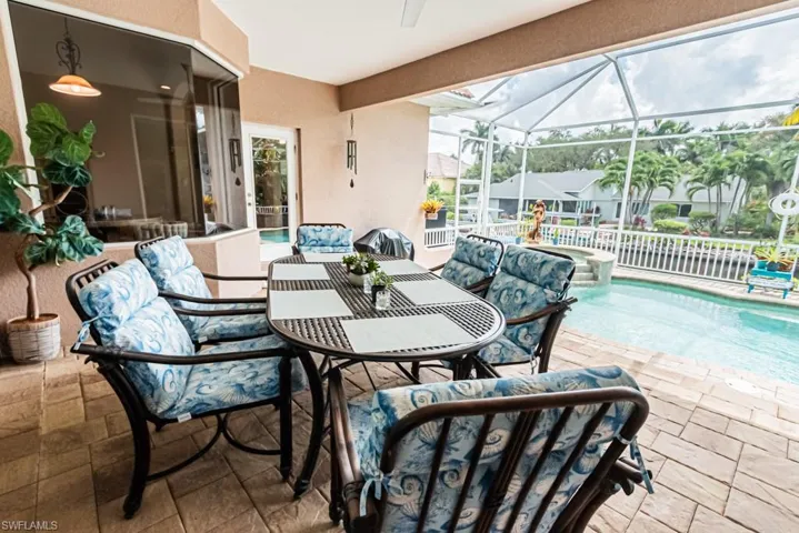 View of patio / terrace featuring a sunroom, an outdoor poo and spa, outdoor dining space with ceiling fan