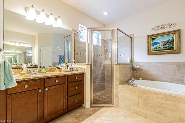 Bathroom with vanity, a shower stall, a bath, and light tile patterned flooring