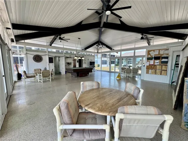 Dining space featuring billiards, speckle patterned floor, floor to ceiling windows, and a towering ceiling