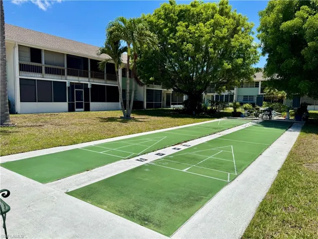 View of home's community with a yard and shuffleboard
