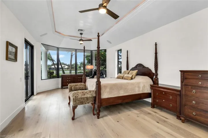 Ground floor primary bedroom with bay window, two sets of sliding glass doors, as well as, french doors which open to the pool lanai