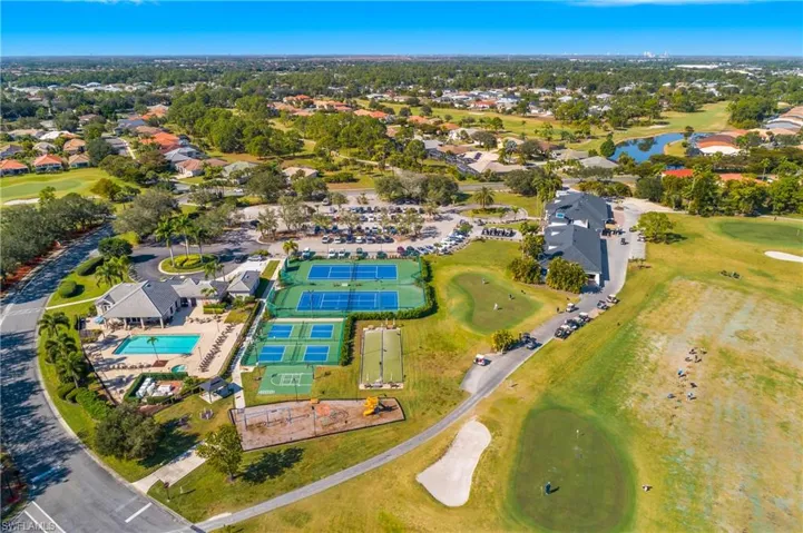 Aerial view of property and surrounding area featuring a local golf course, and a nearby body of water