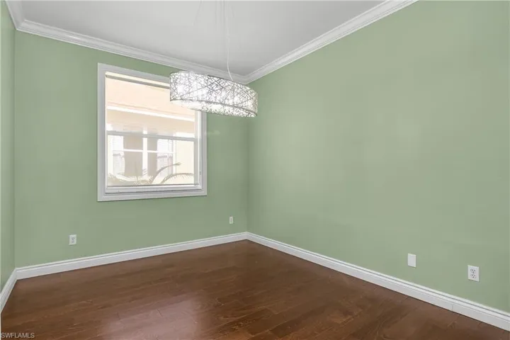 Dining area with wood style floors and crown molding