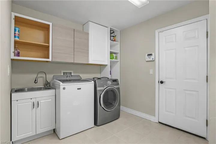 Laundry room featuring cabinet space, separate washer and dryer, and light tile patterned floors