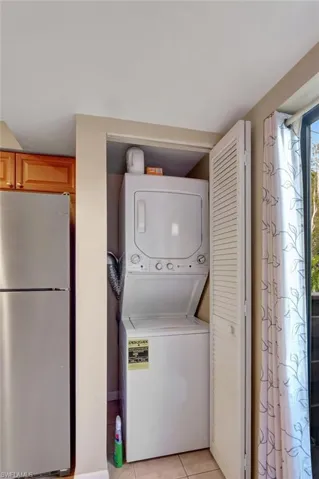Laundry room with tile floors and stacked washer / drying machine