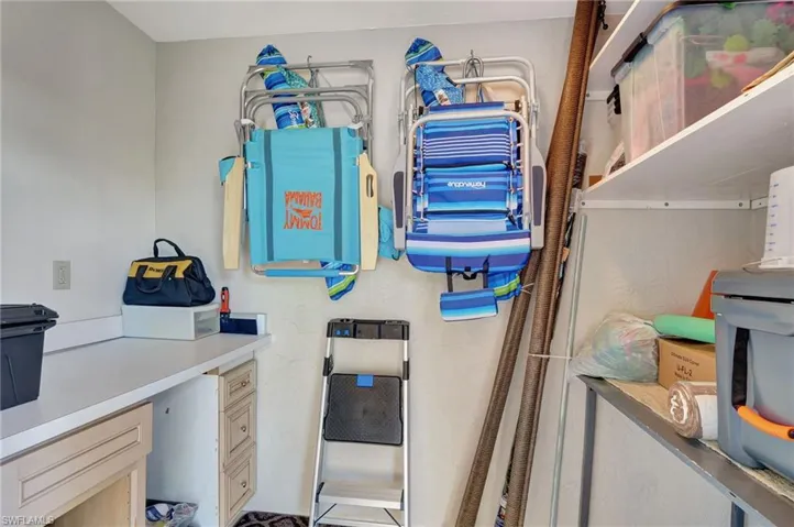 Storage room off lanai with countertop for hobby work and plenty of shelving
