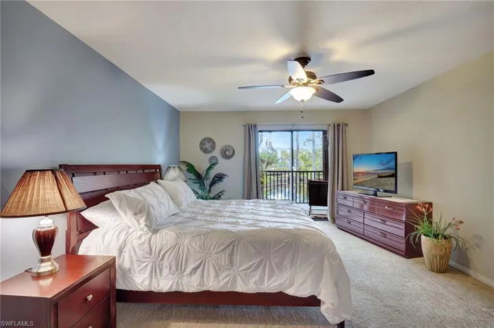 Carpeted bedroom with ceiling fan and large sliders to the Lanai offering beautiful views of the pond and preserve