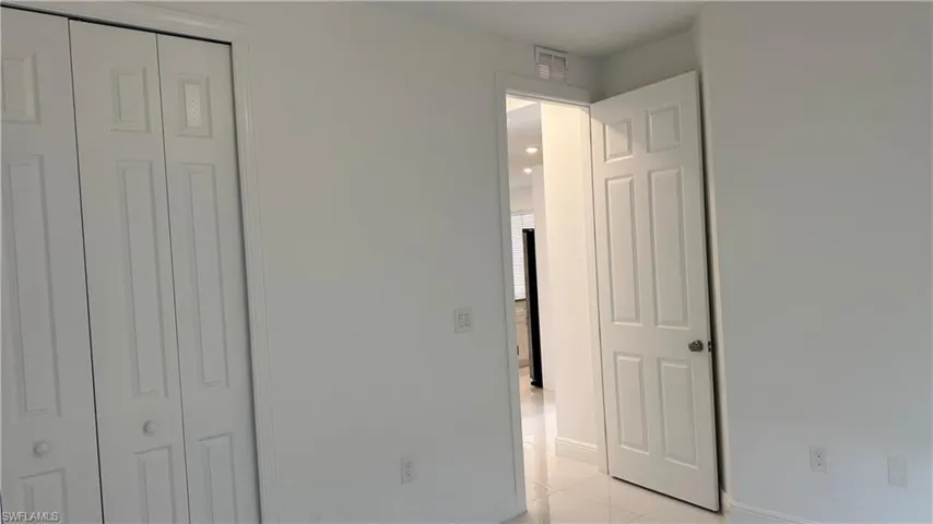 Unfurnished bedroom with a closet and light tile patterned floors