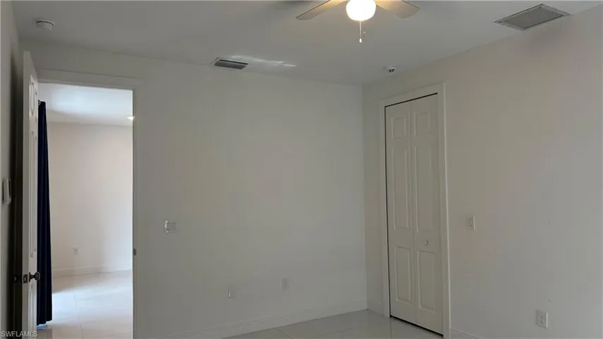 Spare room with light tile patterned floors and a ceiling fan