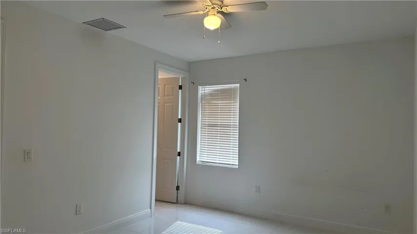 Empty room featuring a ceiling fan and light tile patterned floors