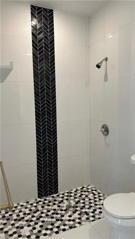 Bathroom with a shower stall and toilet