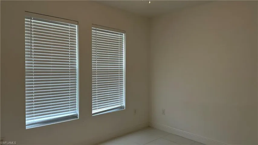 Spare room with light tile patterned floors and baseboards
